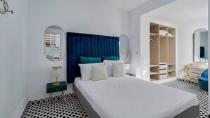 A modern bedroom with a large bed, a wardrobe, and a mirror. - Minty House (Setúbal)