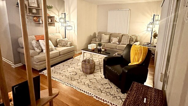 A living room with a sofa, armchair, coffee table, and a patterned rug. - Spacious & Cozy Unit in the Heart of Milwaukee (milwaukee)
