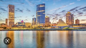 A city skyline with modern high-rise buildings, a river in the foreground, and a distinctive bridge structure. - Spacious & Cozy Unit in the Heart of Milwaukee (milwaukee)