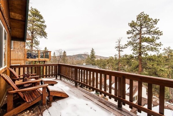 Relax on the deck with a view of the surrounding houses and trees.