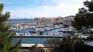 Un port de plaisance où de nombreux bateaux sont amarrés, entouré d’immeubles et d’arbres.