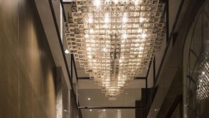 A corridor with a modern chandelier and marble flooring. - Nanjing Golden Eagle International (Nanjing)