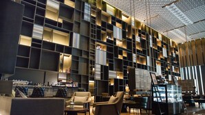 A modern interior with a geometric shelving unit, leather seating, and a central counter with a display case. - Nanjing Golden Eagle International (Nanjing)