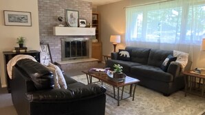 A living room with a fireplace, a sofa, a coffee table, and a lamp.