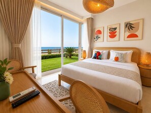 A hotel room with a bed, a desk with a remote control, a chair, a lamp, and a view of the sea. - Outstanding Sea View-Azzurra Apartments (Sahl Hasheeh)