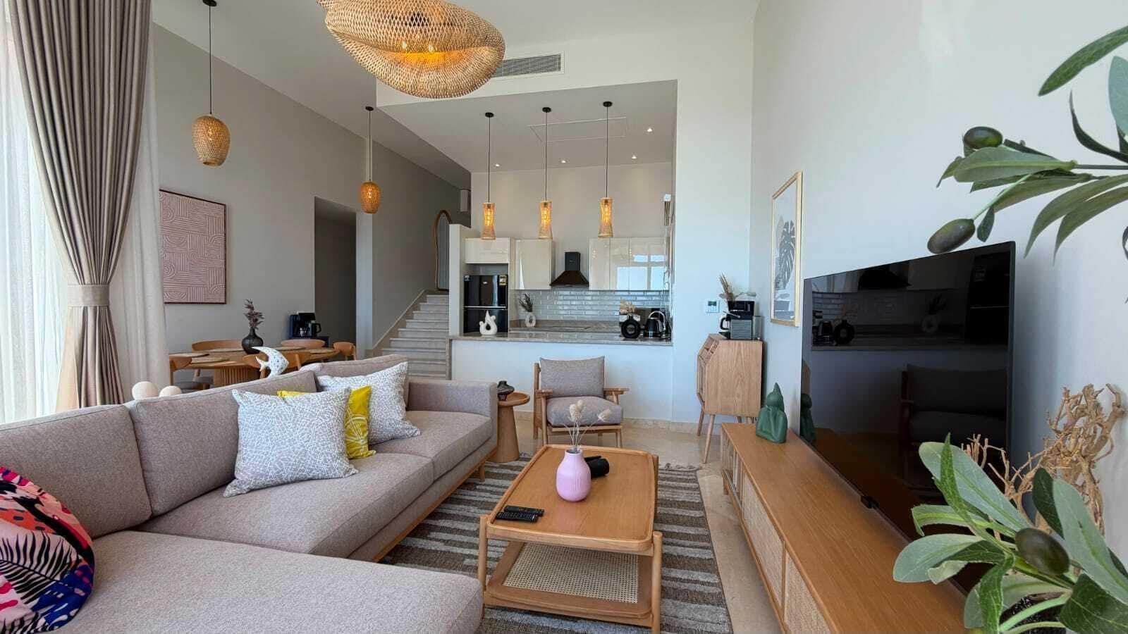 Een moderne woonkamer met een bank, salontafel en een flatscreen televisie.