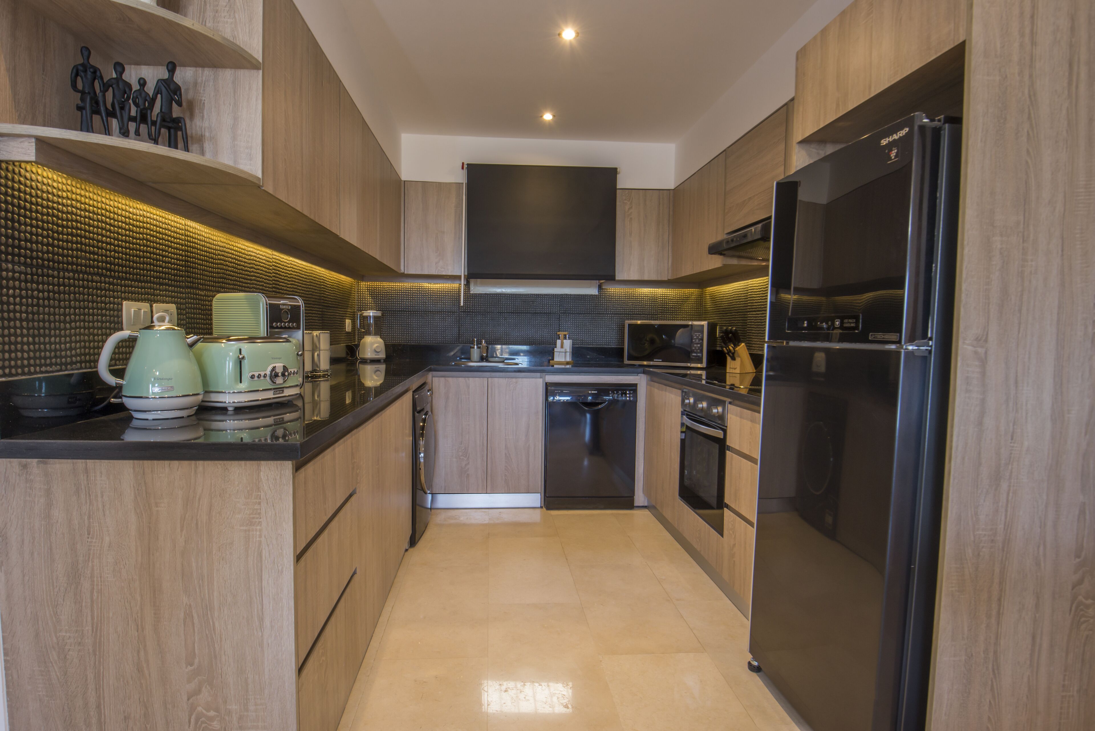 A modern kitchen with wooden cabinets, a black refrigerator, a dishwasher, and a microwave.