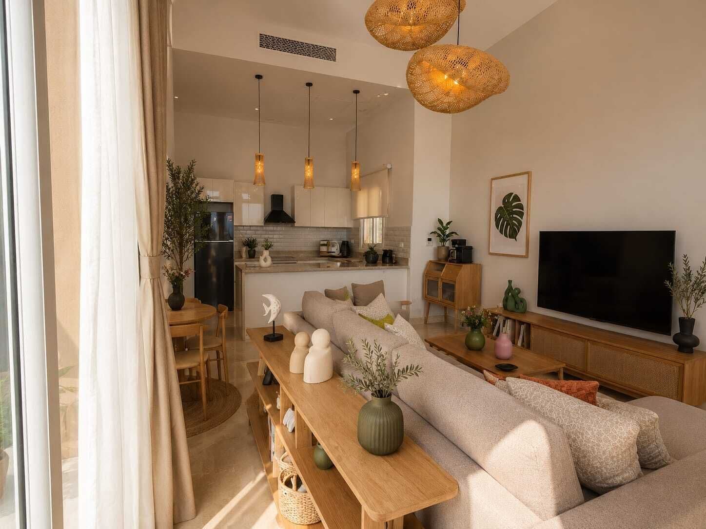 Ein modernes Wohnzimmer mit einer Couch, einem Holztisch und einem Fernseher.
