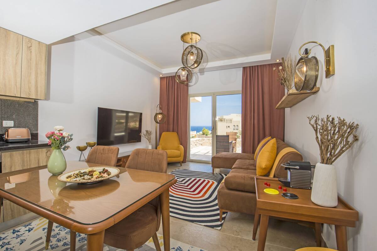 A modern living room with a dining area, a sofa set, a coffee table, and a TV.