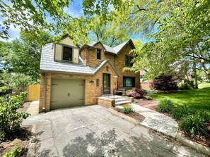 A two-story house with a garage, a front porch, and a well-maintained lawn. - Country Club Charm (Omaha)
