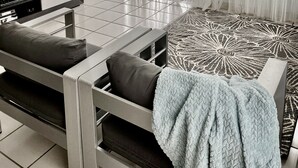 A modern living room with a sofa, TV, and a patterned rug. - AQUA VILLA steps from the beach (Luquillo)