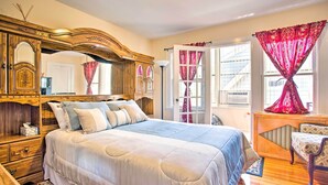 Ein Schlafzimmer mit einem großen Bett, Holzmöbeln und einem Fenster mit Vorhängen.