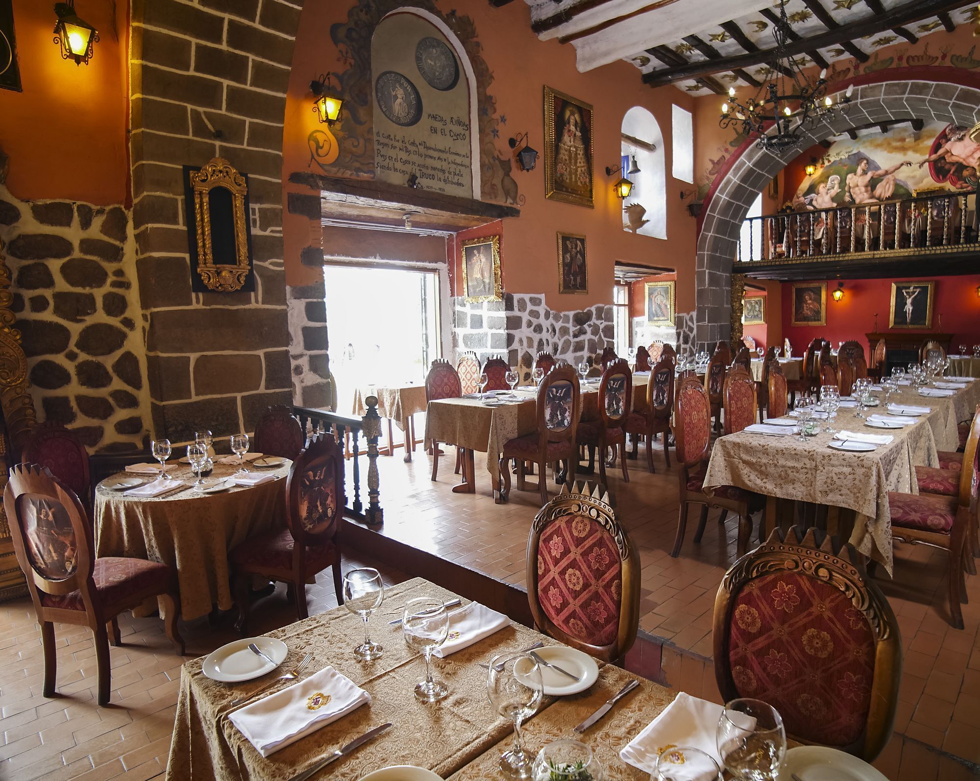 A restaurant with stone walls, wooden tables, and chairs.