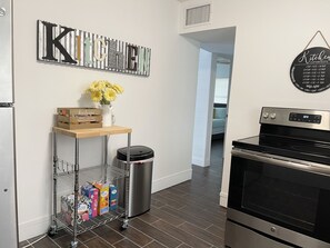 Modern kitchen with stainless steel appliances, oven, and wall-mounted clock.