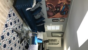 A living room with a patterned rug, a blue sofa, a coffee table, and a painting on the wall. - Luxury Lake House  (Atlanta)