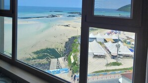 A view from a window overlooking a beach with clear skies. - Saint Beach Hotel (Jeju City)