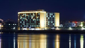 A multi-story hotel with a modern design, featuring a prominent corner location with a waterfront view. - Saint Beach Hotel (Jeju City)