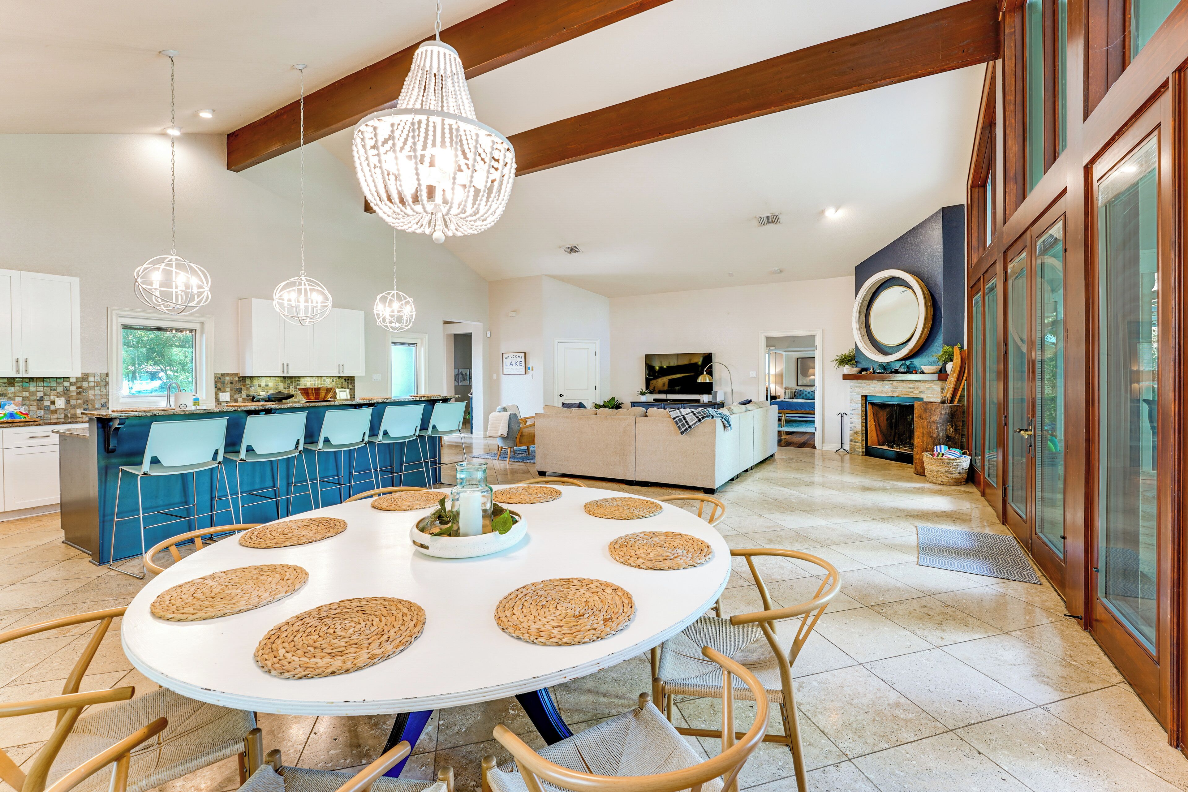 Une cuisine spacieuse dotée d’un îlot central, de luminaires suspendus et d’un coin repas avec une table ronde.