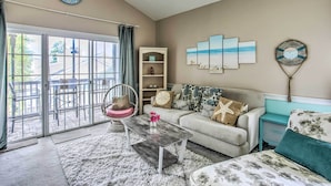 A living room with a sofa, coffee table, and artwork on the wall. - Lovely Myrtle Beach Condo: 4 Mi to Boardwalk! (Myrtle Beach)