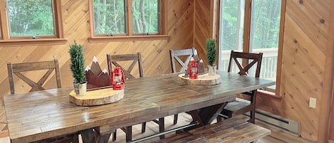 Enjoy meals in this cozy dining area with a long table for four, a bench, and a potted plant.