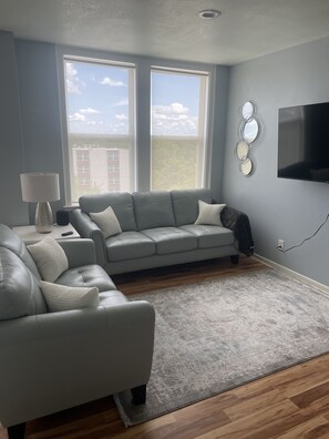 Relax in this stylish living room with a large sectional sofa, armchair, and flat-screen TV.