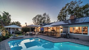 Una casa moderna con piscina, mobiliario exterior y zona de patio.