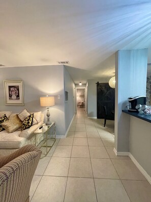 Relax in a stylish living space with a sofa, side table, and framed artwork.