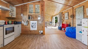Ein Holzinnenraum mit Küche, Essbereich und Wohnzimmer mit blauem Sitzsack.