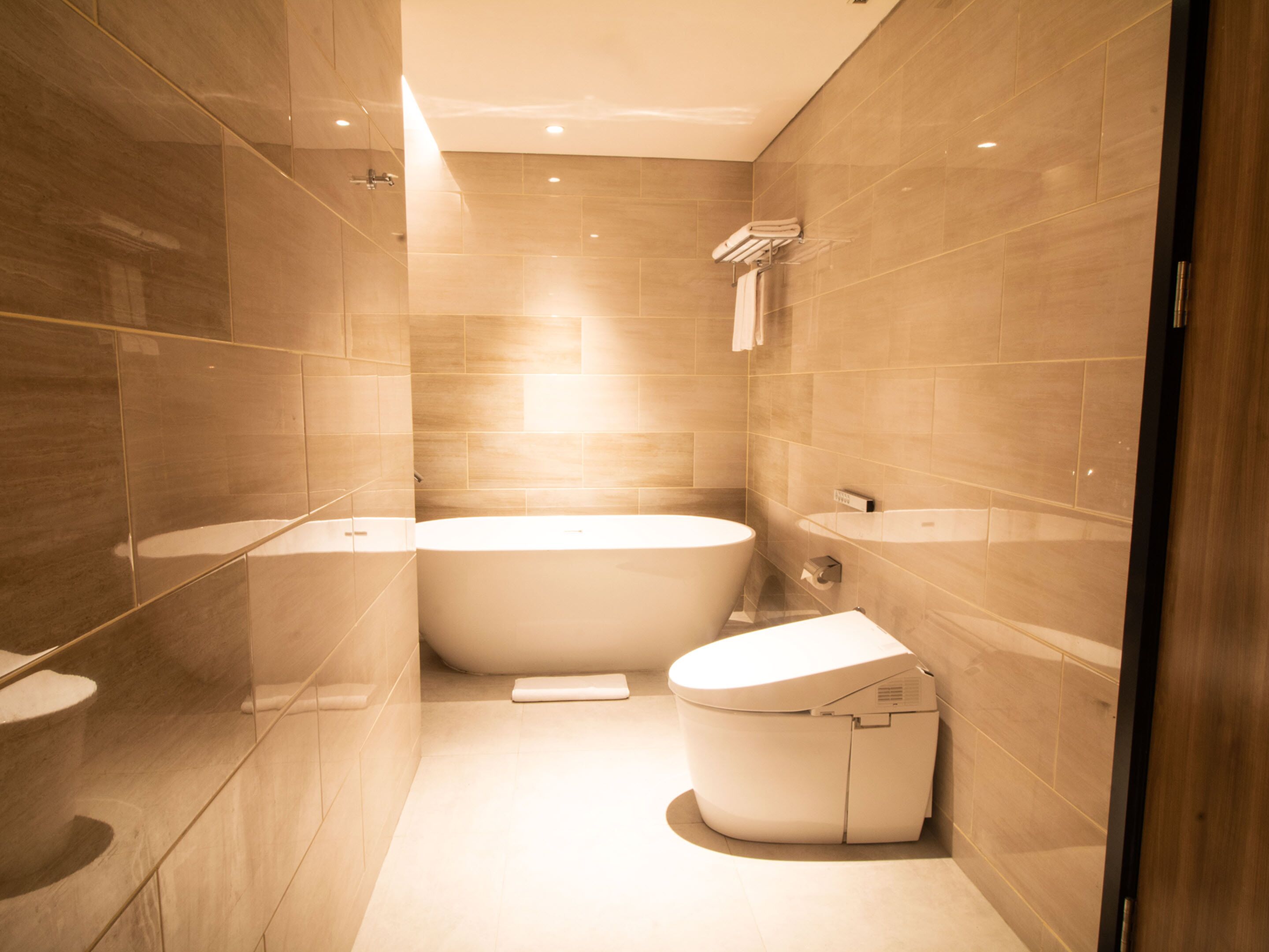 Un baño moderno con una bañera independiente, un inodoro y un tocador.