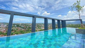 An infinity pool with a clear view of a cityscape and mountains in the background. - Prime Park Hotel & Convention Lombok (Mataram)