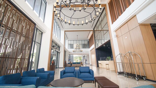 A spacious lobby with a high ceiling, modern furniture, and a large chandelier. - Prime Park Hotel & Convention Lombok (Mataram)