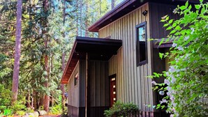 A modern wooden cabin with a gravel driveway, surrounded by dense forest. - Mt Baker Luxury Cabin • 2 King Beds • Hot Tub • Game Loft • Firepit (Deming)