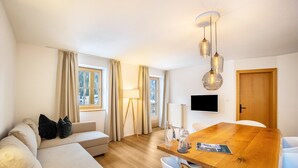 Ein modernes Wohnzimmer mit einer Couch, einem Holzessttisch und einer Lampe.