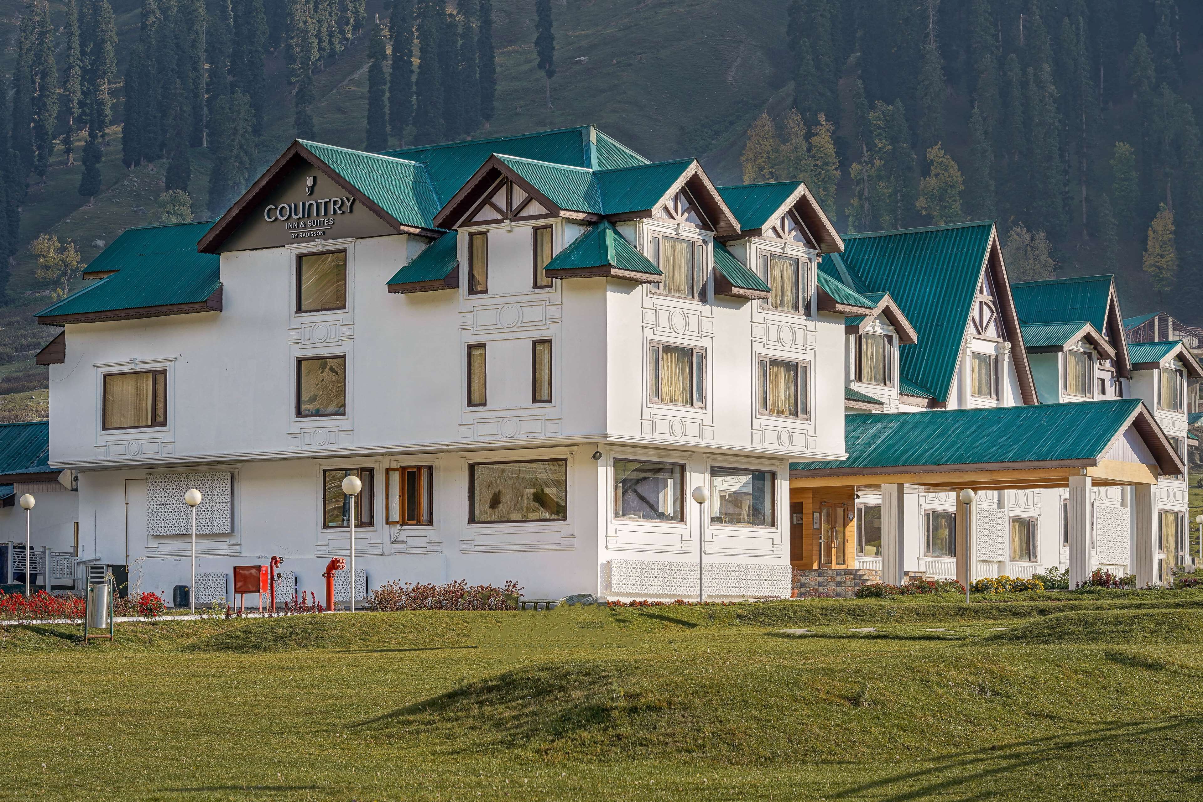 A hotel with a traditional architectural style, featuring multiple windows and a green roof.