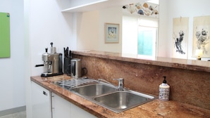 A kitchen with stainless steel sinks, a coffee machine, and a decorative soap dispenser. - StayCentral - Fairfield 4Br Home (Fairfield)