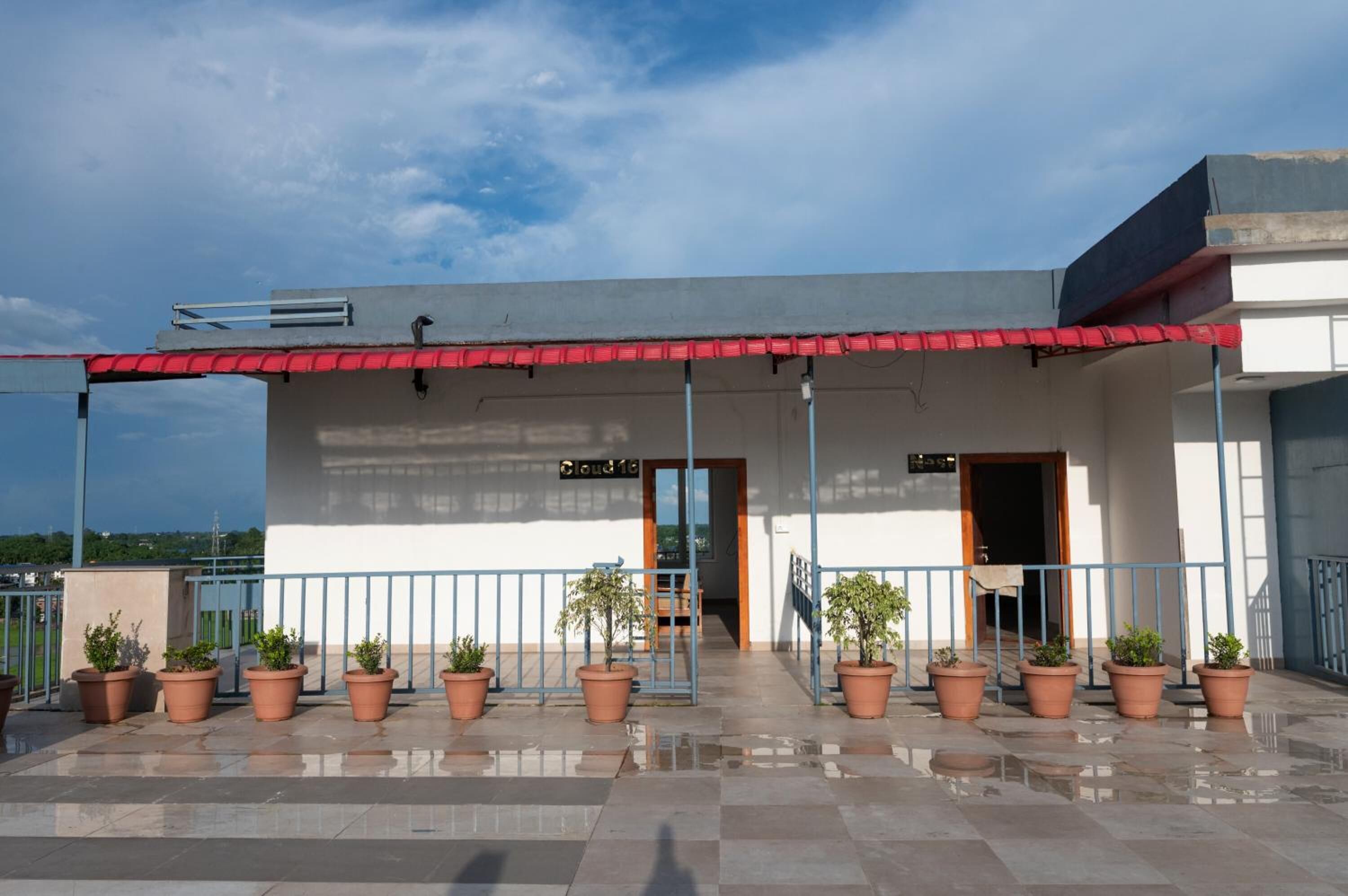 A building with a red awning, a sign reading "Cloud 10", and potted plants in front.