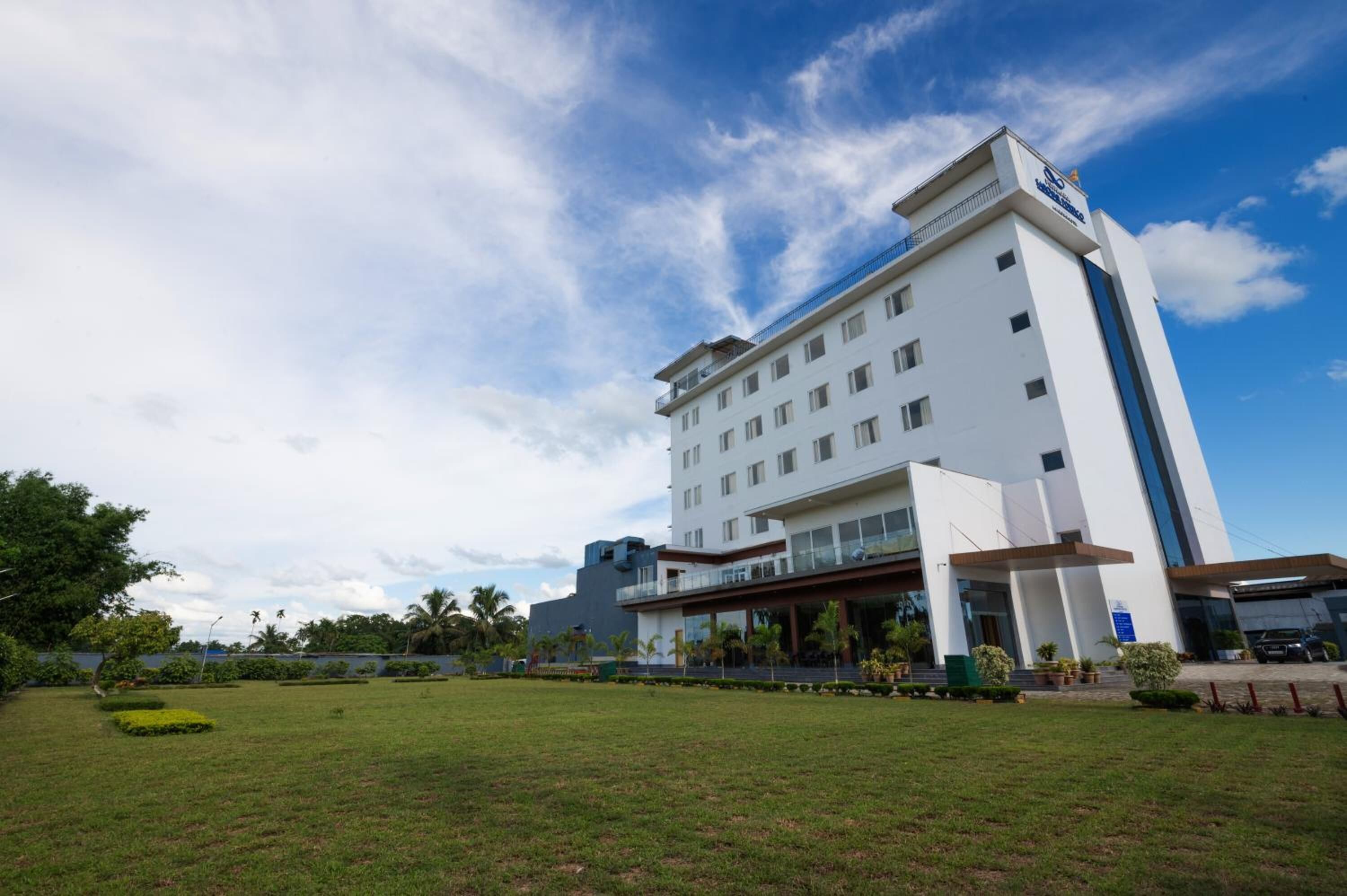 Un hotel moderno con fachada blanca, varios pisos y techo plano.