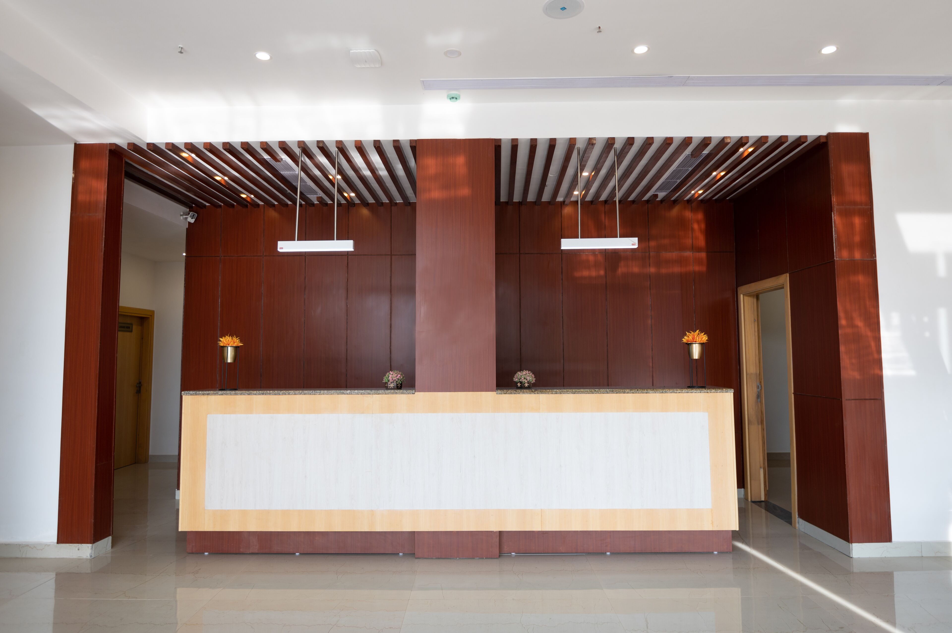 A reception desk with a wooden finish, two pendant lights, and a clean, modern design.