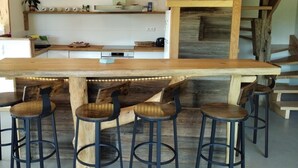 Une cuisine rustique avec un îlot central en bois et des tabourets de bar.