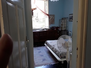A bedroom with a bed, a bedside table, a window, and a fan. - Room in Guest Room - Valle Degli Ulivi - Liguria, Italia (Diano San Pietro)