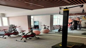 A gym with stationary bikes, elliptical machines, and exercise balls. - Ramada Encore by Wyndham Qingdao Shinan (Qingdao)