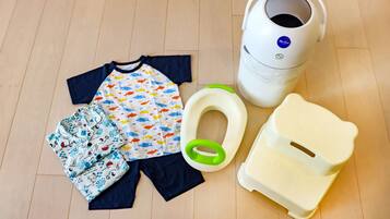 A child's potty training setup including a potty, toilet paper, and a potty seat.