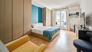 Een moderne hotelkamer met een bed, een bureau, een stoel en uitzicht.