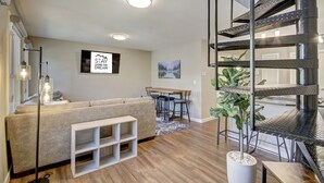 A modern living room with a sofa, a dining area, and a staircase. - A Ridge above the Rest!  New Remodel and High End Upgrades (Breckenridge)