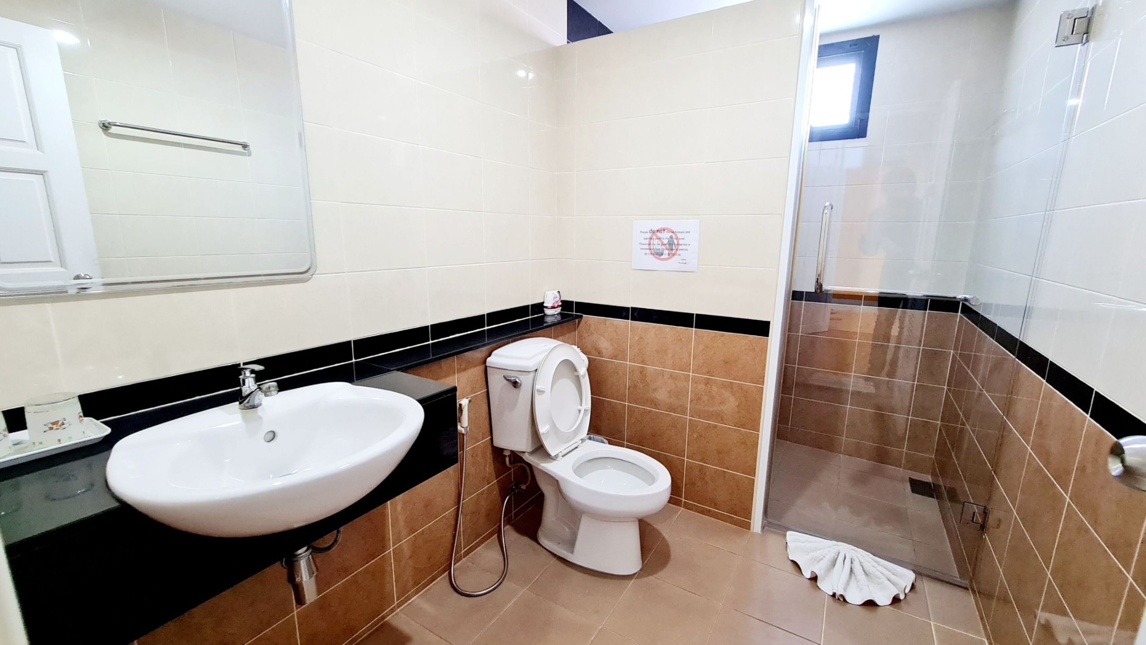 Un baño con lavamanos, inodoro y zona de ducha.