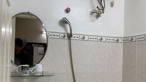 Kylpyhuone, jossa on pesuallas, peili, suihku, wc ja seinään asennettu lämmitin.
