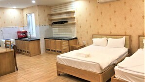 Ein Hotelzimmer mit einem Holzbett, einer kleinen Küchenzeile und einer Klimaanlage.