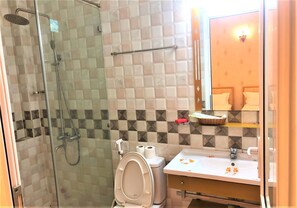 A bathroom with a shower, toilet, and sink.