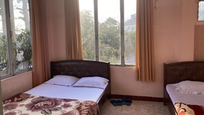 A room with two beds, a window with curtains, a tiled floor, and a pair of slippers on the floor. - Thu Tam Hotel (Cam Ly - Da Lat)