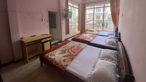 A hotel room with two beds, a desk, and a television. - Thu Tam Hotel (Cam Ly - Da Lat)